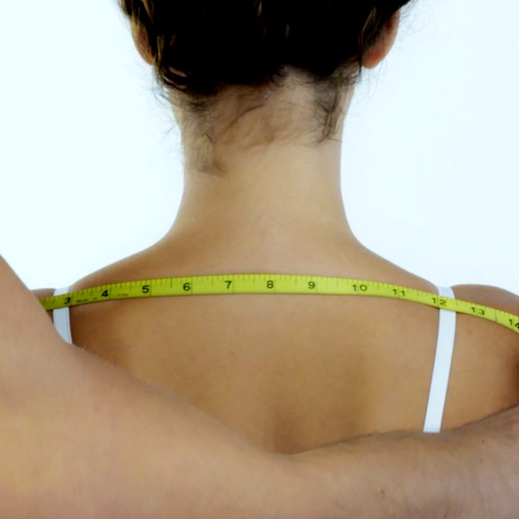female getting shoulders measured