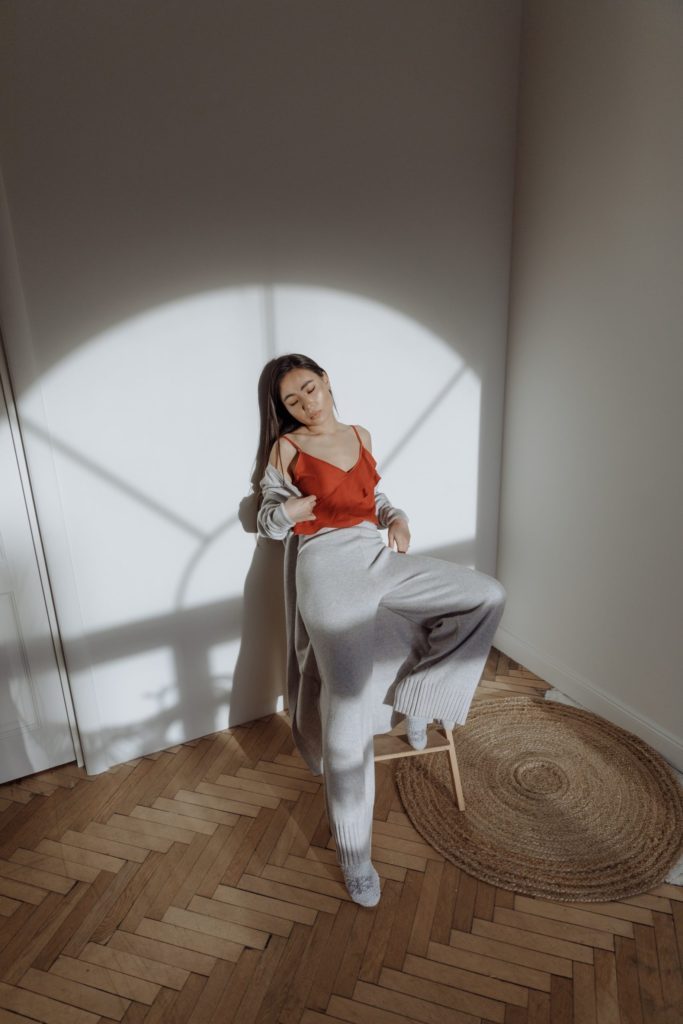 A woman embracing the athleisure trend while sitting on a chair in a room.