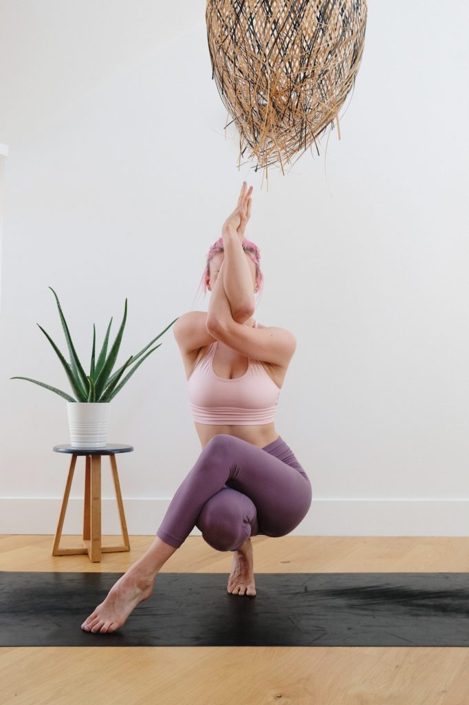 A woman practicing yoga on a yoga mat, demonstrating the modern athleisure trend.